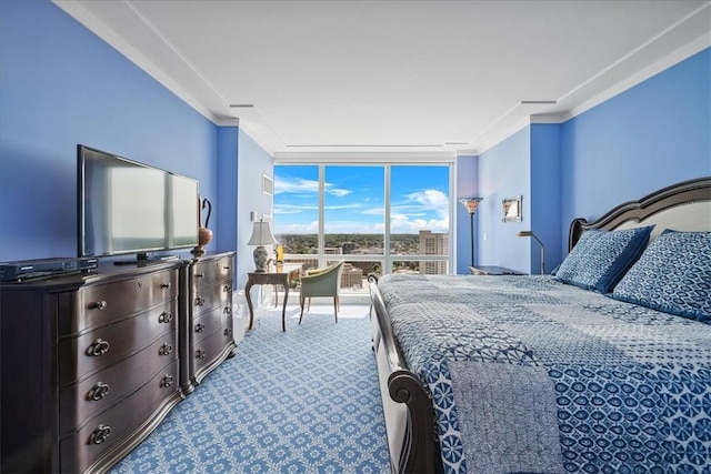 carpeted bedroom with crown molding and a wall of windows