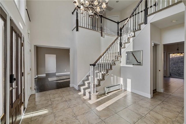 foyer entrance with a chandelier, a towering ceiling, and baseboard heating