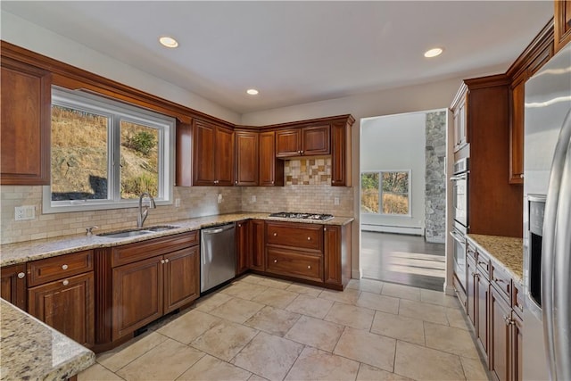 kitchen with appliances with stainless steel finishes, backsplash, a wealth of natural light, and sink