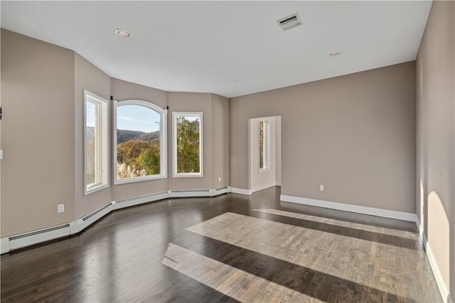 empty room with dark wood-type flooring and a baseboard heating unit