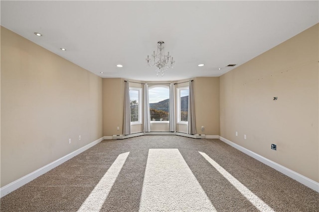 carpeted empty room with a notable chandelier