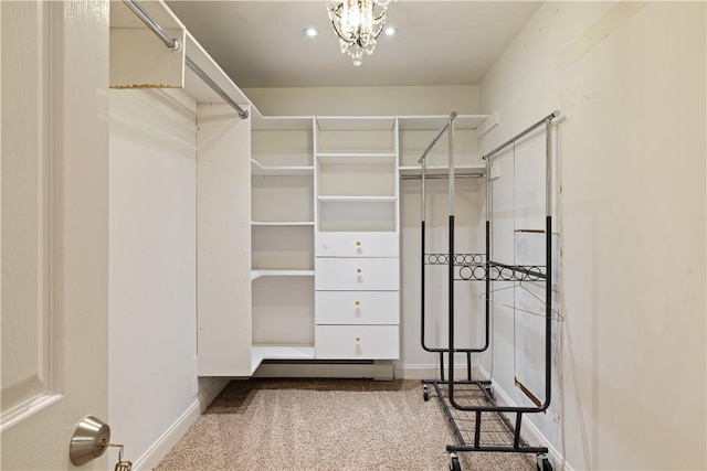 walk in closet with carpet floors and a notable chandelier