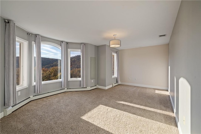 carpeted spare room featuring a baseboard radiator