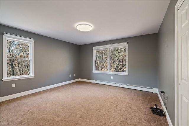 carpeted empty room featuring plenty of natural light and a baseboard radiator