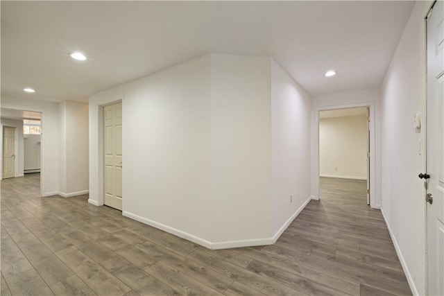 corridor featuring hardwood / wood-style floors and a baseboard radiator