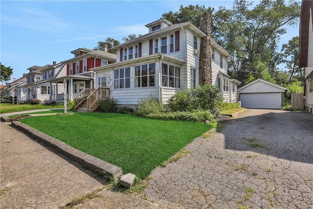 view of front of home featuring an outbuilding, a front yard, and a garage