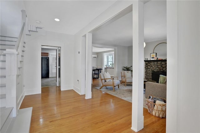 entryway featuring a stone fireplace and hardwood / wood-style flooring