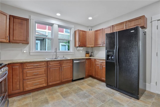 kitchen featuring sink, light stone countertops, and stainless steel appliances