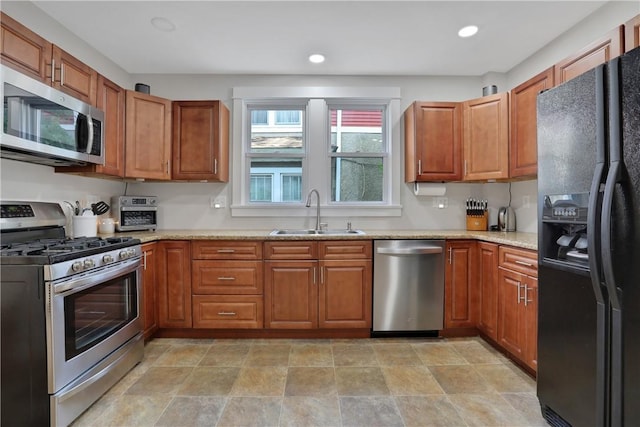 kitchen with light stone countertops, sink, and stainless steel appliances