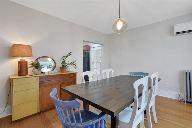 dining space with radiator heating unit, light hardwood / wood-style flooring, and an AC wall unit