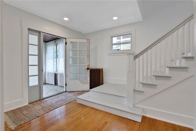 foyer entrance with wood-type flooring and radiator