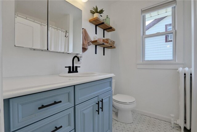 bathroom featuring radiator heating unit, vanity, a shower with shower curtain, and toilet