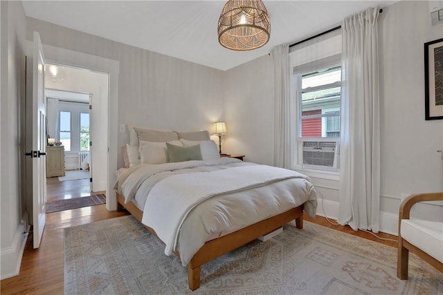 bedroom with light hardwood / wood-style floors and cooling unit