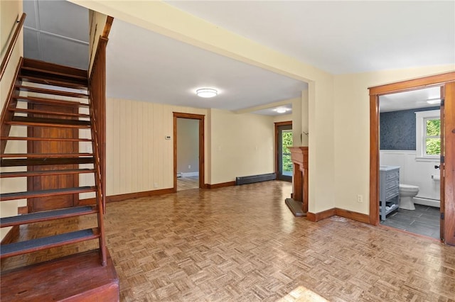 interior space featuring baseboard heating, a fireplace, and parquet floors