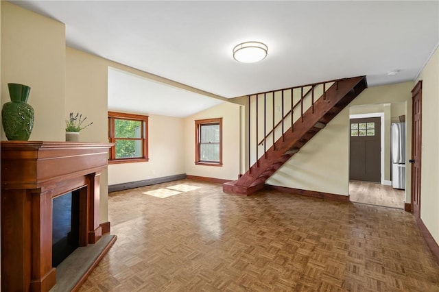 unfurnished living room featuring dark parquet flooring and vaulted ceiling