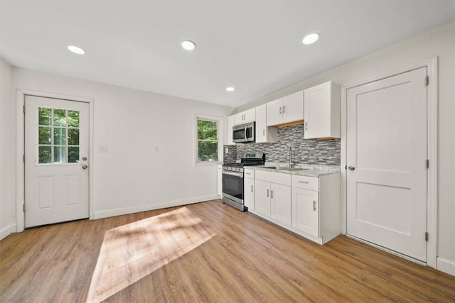 kitchen featuring white cabinetry, plenty of natural light, light hardwood / wood-style flooring, and appliances with stainless steel finishes