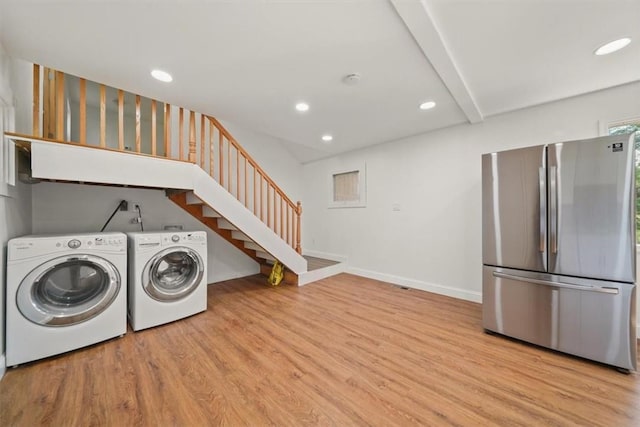 laundry area featuring separate washer and dryer and light hardwood / wood-style flooring