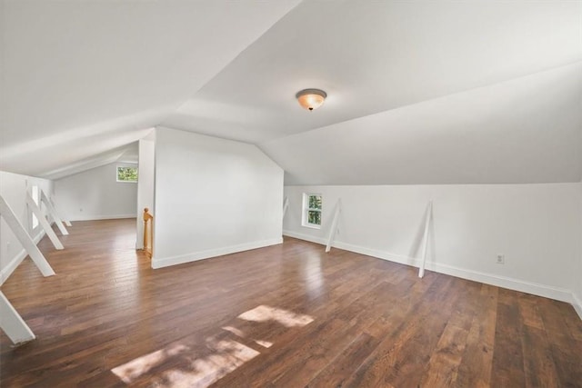 bonus room featuring dark wood-type flooring and vaulted ceiling