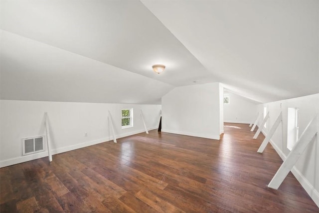 bonus room with dark hardwood / wood-style flooring and vaulted ceiling