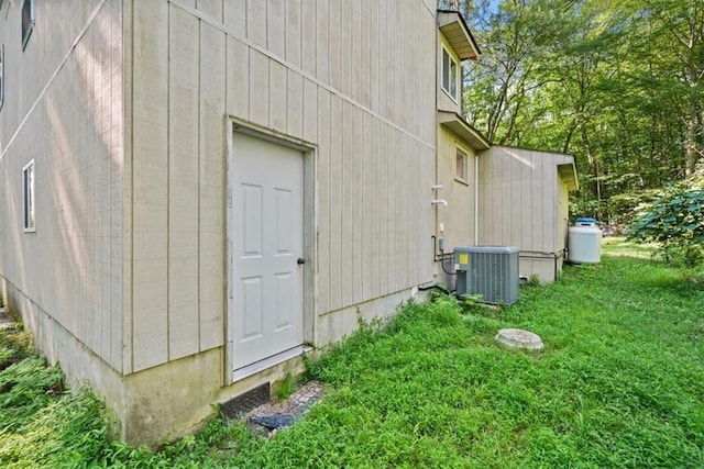 view of property exterior featuring a yard and central AC