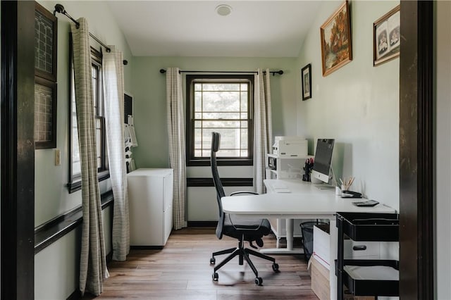 home office featuring lofted ceiling and light wood-type flooring