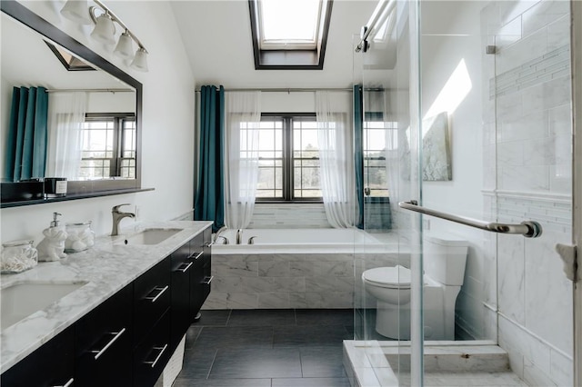 full bathroom featuring vanity, a healthy amount of sunlight, toilet, and a skylight