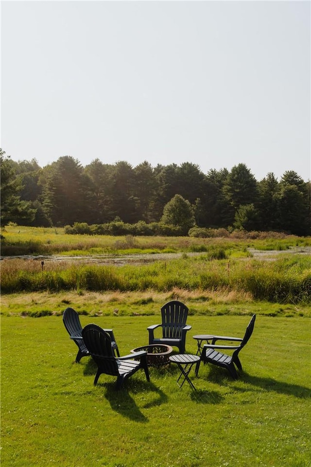 view of property's community with a yard and a fire pit