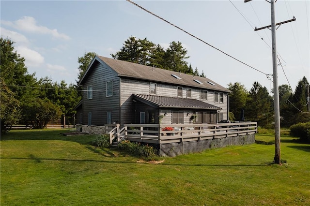 back of house featuring a lawn and a wooden deck