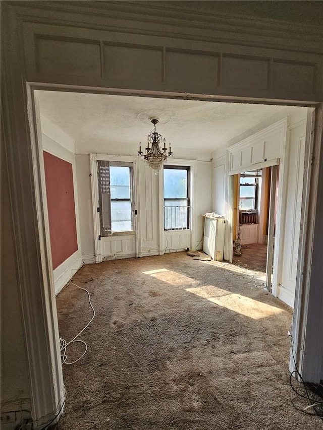 misc room featuring carpet flooring and a chandelier