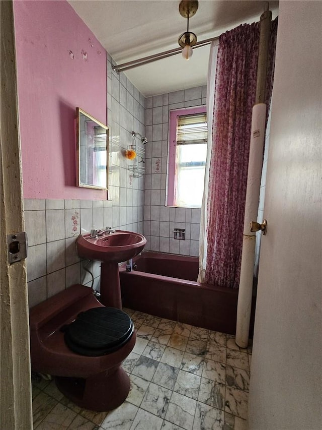 full bathroom featuring sink, shower / tub combo with curtain, tile walls, and toilet