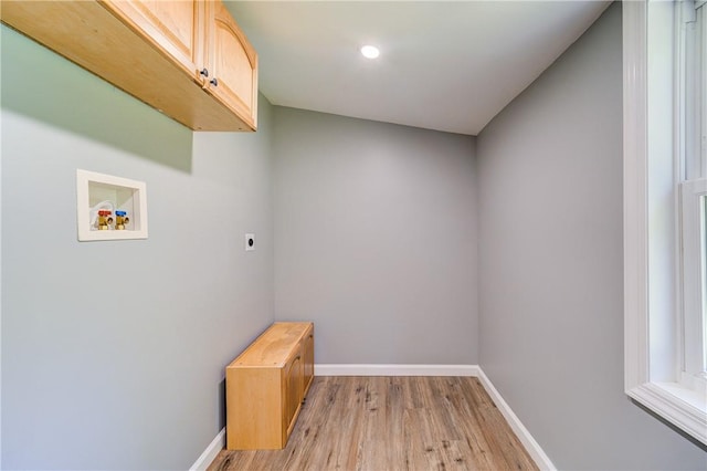 clothes washing area with cabinets, hookup for a washing machine, light hardwood / wood-style floors, and hookup for an electric dryer