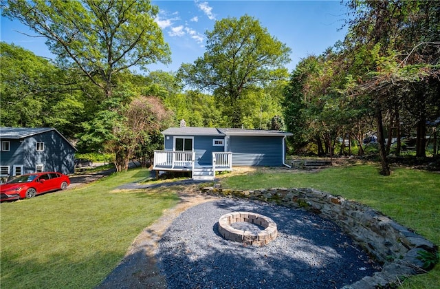 view of yard featuring a wooden deck and a fire pit