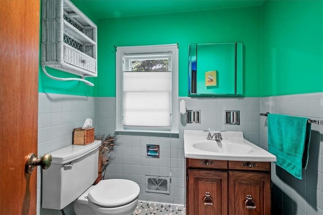 bathroom featuring tile patterned flooring, vanity, toilet, and tile walls