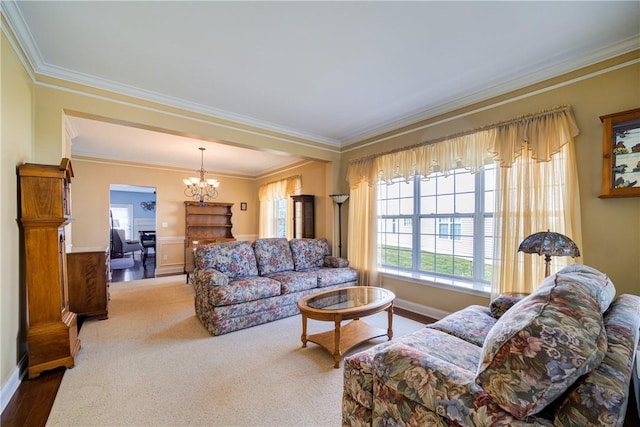 living room featuring hardwood / wood-style floors, ornamental molding, and an inviting chandelier