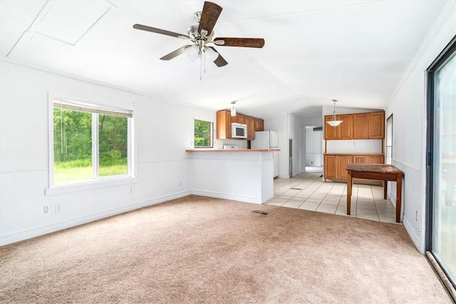 unfurnished living room featuring ceiling fan, light colored carpet, ornamental molding, and vaulted ceiling