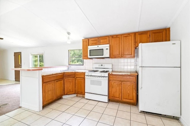 kitchen featuring white appliances, sink, decorative backsplash, light colored carpet, and kitchen peninsula