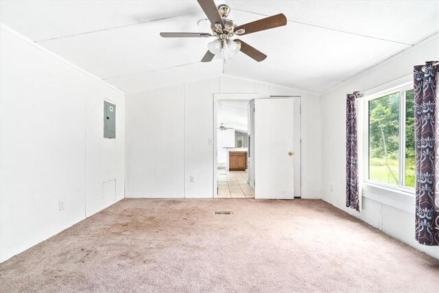 carpeted empty room featuring ceiling fan, lofted ceiling, and electric panel