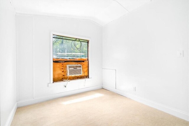 unfurnished room with carpet flooring, vaulted ceiling, and cooling unit