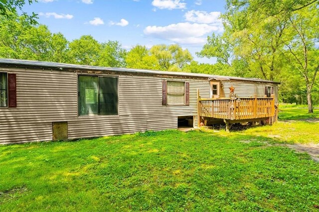 rear view of property featuring a yard and a deck