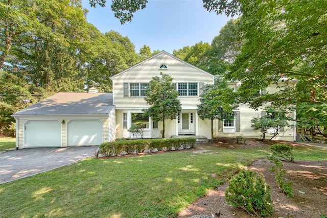 view of front of home with an attached garage, a front lawn, and aphalt driveway