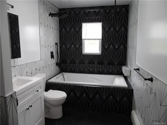 full bathroom featuring tiled shower / bath combo, tile patterned floors, toilet, vanity, and tile walls