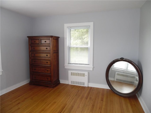 unfurnished room with radiator heating unit and light hardwood / wood-style flooring