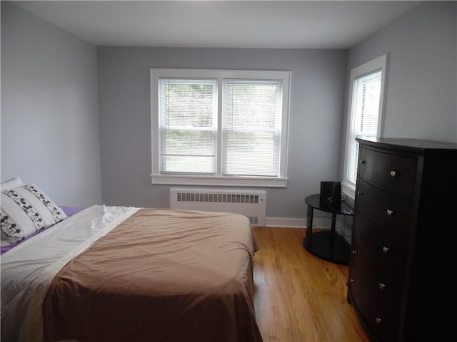 bedroom featuring light wood-type flooring and radiator heating unit