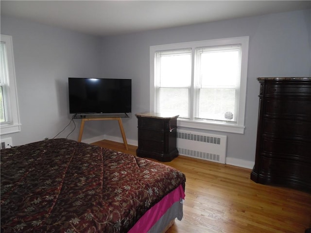 bedroom featuring light hardwood / wood-style floors and radiator heating unit