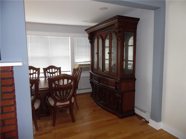 dining room with wood-type flooring, baseboard heating, and cooling unit