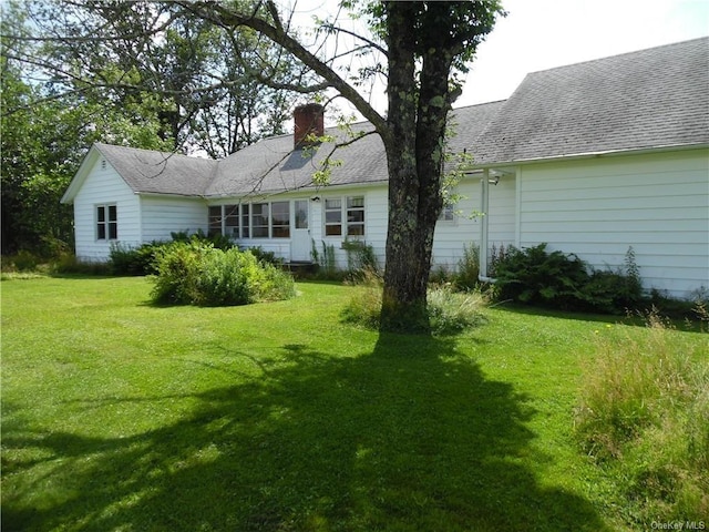 rear view of house featuring a yard