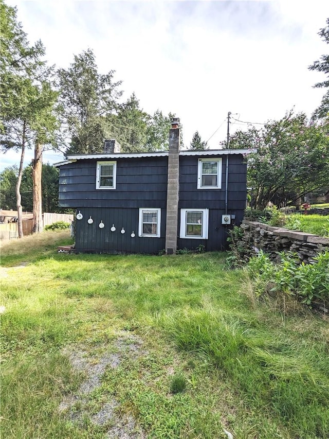 rear view of property featuring a lawn