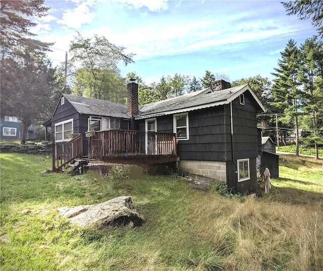 rear view of house with a deck and a yard