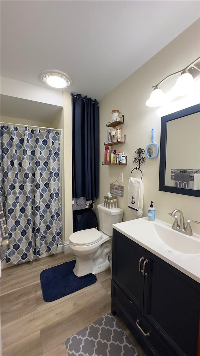 bathroom featuring toilet, vanity, and hardwood / wood-style flooring