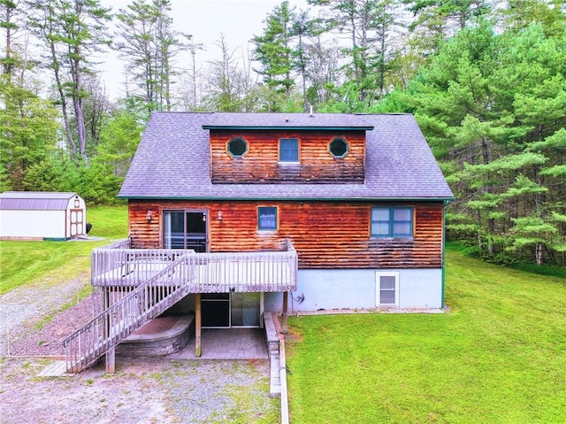 rear view of property with a shed, a yard, a patio, and a wooden deck